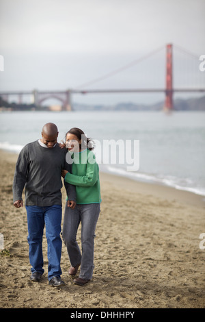 Afrikanische amerikanische paar Fuß die San Francisco Strand Arm in arm, noch in der Liebe nach all diesen Jahren durch dick und dünn. Stockfoto