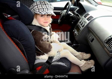 Mädchen in einem Kindersitz im Auto, Scania, Schweden Stockfoto