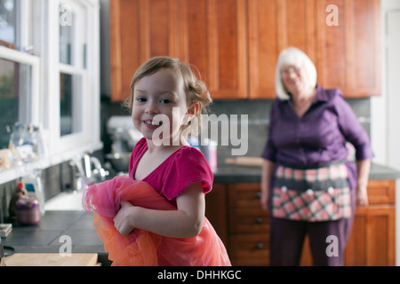 Mädchen und Großmutter in der Küche stehen Stockfoto