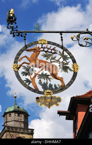 Hängende Zeichen der Pension und ehemalige Brauner Hirsch-Brauerei, 18. Jahrhundert, vor dem Turm der katholischen Pfarrei Stockfoto