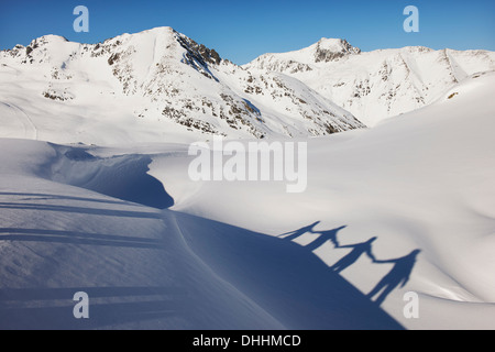 Schatten der vier Freunde Hand in Hand im Schnee, Kühtai, Österreich Stockfoto