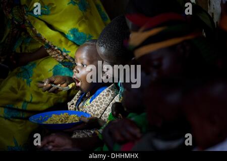 Kayanza, Burundi. 23. September 2013. Ein Junge ist ein älterer Junge in einem Dorf in der Nähe von Kayanza, Burundi, 23. September 2013 gespeist wird. Frauen des Dorfes gekocht einen Eintopf mit Bohnen, Kartoffeln, Bananen und Erdnüsse für unterernährte Kinder des Dorfes zu einer Mahlzeit. Foto: Thomas Schulze/Dpa/Alamy Live News Stockfoto