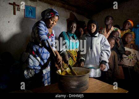 Kayanza, Burundi. 23. September 2013. Lokalen Gesundheitsassistenten Stefan (L) kocht mit Frauen des Dorfes einen Eintopf mit Bananen, Bohnen, Kartoffeln und Erdnüssen, eine Mahlzeit für unterernährte Kinder des Dorfes in der Nähe von Kayanza, Burundi, 23. September 2013 bereitzustellen. Foto: Thomas Schulze/Dpa/Alamy Live News Stockfoto