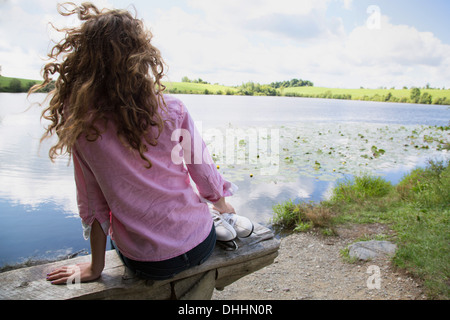 Teenager-Mädchen sitzen auf Bank mit Schlittschuhen Stockfoto