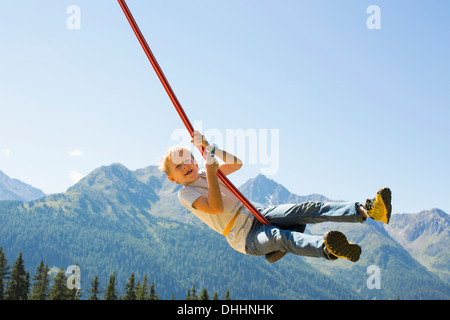 Jungen spielen auf Schaukel, Tirol, Österreich Stockfoto