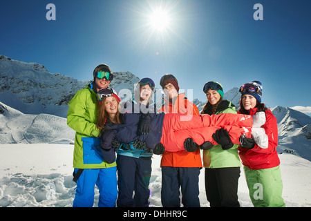 Freunde halten Frau im Schnee, Kühtai, Österreich Stockfoto