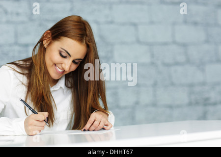 Junge glücklich Geschäftsfrau unterzeichnende Dokument Stockfoto