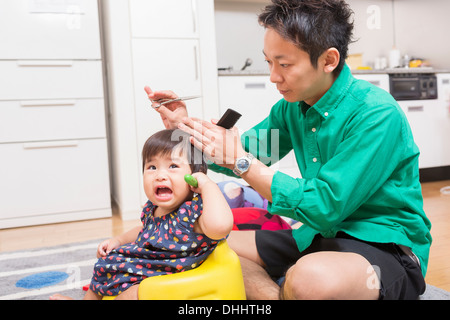 Vater des Babys schneiden Haare auf Boden Stockfoto