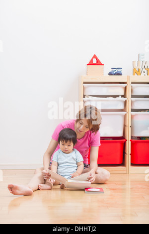 Mutter Lesung Baby Erdgeschoss Stockfoto