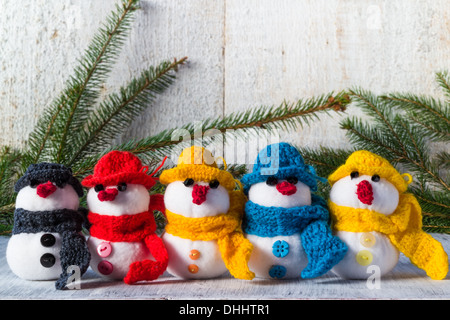 Familie Plüsch Schneemänner auf weißem Holz Hintergrund Stockfoto