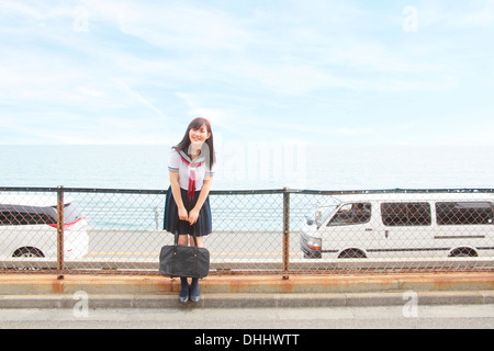 Junge Frau tragen Schuluniform, Tragetasche Stockfoto
