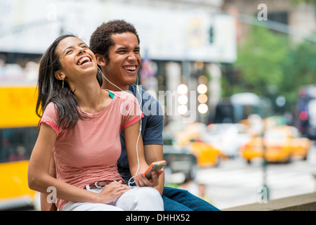 Paar anhören von Musik auf dem Handy Stockfoto