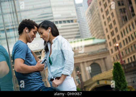 Paar anhören von Musik auf dem Handy Stockfoto