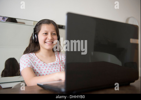 Teenager-Mädchen mit Kopfhörern mit laptop Stockfoto