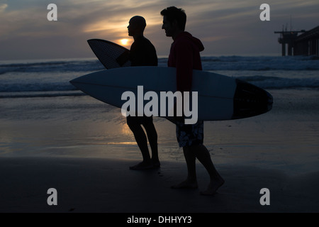 Surfer am Strand von Silhouette Stockfoto