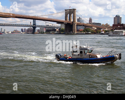 New York Police Department NYPD Patrouillenboot unterquert die Brooklyn Bridge über den Hudson River, New York, USA Stockfoto