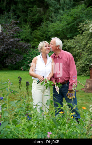 Porträt von senior paar teilen einen Kuss im Garten Stockfoto