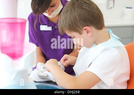 Zahnmedizinische Patienten üben Zahnseide auf Zahnersatz Stockfoto