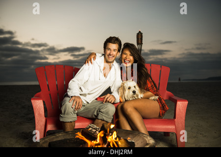 Junges Paar sitzt am Lagerfeuer am Mission Beach, San Diego, Kalifornien, USA Stockfoto