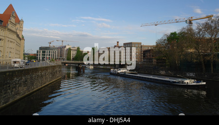 Blauer Himmel Morgengrauen Ansicht vom Monbijoubrucke in Richtung Ebertbrucke, lange Cargo Schiff bewegen Osten entlang Spree, Berlin, Deutschland Stockfoto