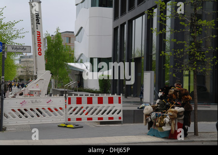 Mann trägt rote Stern Mütze stehende Pflaster stall verkaufen touristische Souvenirs, Wollmützen, militärische Mützen, Voss Strasse, Berlin Stockfoto