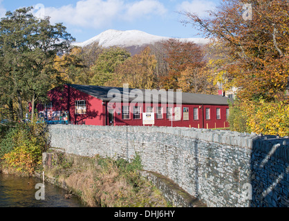 Keswick Bleistift Museum mit River Greta im Vordergrund und Schnee bedeckt Berge im Hintergrund, Cumbria, England, UK Stockfoto