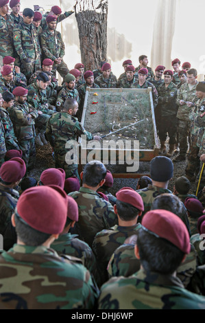 Afghanische Kommandos von der 6. spezielle Operationen Kandak anhören einer Mission briefing 9. November 2013 in der Provinz Kabul, Afghanistan. Der Kommandant der 3. Kompanie, 6. SOK gibt den Brief mit einer Sand-Tabelle, wodurch die Kommandos des Kommandanten Plan zu visualisieren. Stockfoto