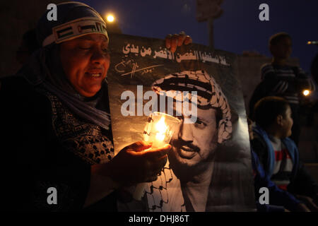 Jerusalem. 11. November 2013. Palästinenser halten Plakate und Kerzen als sie den Tod des verstorbenen palästinensischen Führer Yasser Arafat am Damaskustor in der Jerusalemer Altstadt, 11. November 2013 erinnern. Palästinenser am selben Tag wurden anlässlich des neunten Jahrestages der Arafatss Tod, bedurfte es Tage nach Schweizer Experten sagten, dass er der radioaktive Vergiftung, aber weitere Untersuchung gestorben sein kann. Bildnachweis: ZUMA Press, Inc./Alamy Live-Nachrichten Stockfoto