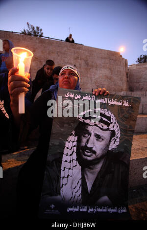 Jerusalem. 11. November 2013. Palästinenser halten Plakate und Kerzen als sie den Tod des verstorbenen palästinensischen Führer Yasser Arafat am Damaskustor in der Jerusalemer Altstadt, 11. November 2013 erinnern. Palästinenser am selben Tag wurden anlässlich des neunten Jahrestages der Arafatss Tod, bedurfte es Tage nach Schweizer Experten sagten, dass er der radioaktive Vergiftung, aber weitere Untersuchung gestorben sein kann. Bildnachweis: ZUMA Press, Inc./Alamy Live-Nachrichten Stockfoto