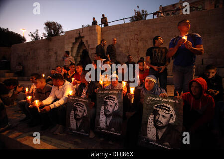 Jerusalem. 11. November 2013. Palästinenser halten Plakate und Kerzen als sie den Tod des verstorbenen palästinensischen Führer Yasser Arafat am Damaskustor in der Jerusalemer Altstadt, 11. November 2013 erinnern. Palästinenser am selben Tag wurden anlässlich des neunten Jahrestages der Arafatss Tod, bedurfte es Tage nach Schweizer Experten sagten, dass er der radioaktive Vergiftung, aber weitere Untersuchung gestorben sein kann. Bildnachweis: ZUMA Press, Inc./Alamy Live-Nachrichten Stockfoto