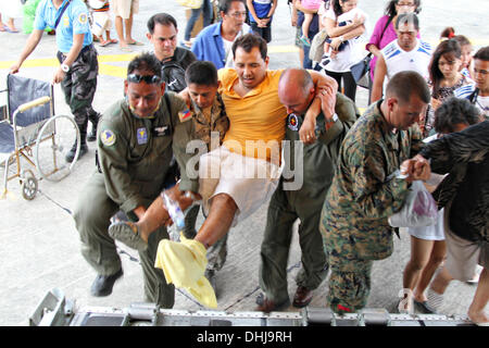 Manila, Philippinen. 11. November 2013. US Marines tragen einen verletzten philippinischen Mann auf einem KC-130J Super Hercules-Transportflugzeuge auf Villamor Air Base 11. November 2013 in Manila, Philippinen. Die USA trat Hilfsmaßnahmen nach den Verwüstungen durch Super Taifun Haiyan, die geglaubt wird, um über die philippinischen Inseln 10.000 Menschen getötet wurden. Stockfoto