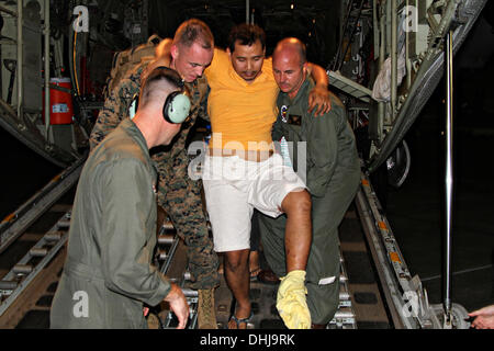 US-Marines tragen einen verletzten philippinischen Mann von der Rückseite des KC-130J Super Hercules Transportflugzeug auf Villamor Air Base 11. November 2013 in Manila, Philippinen. Die USA trat Hilfsmaßnahmen nach den Verwüstungen durch Super Taifun Haiyan, die geglaubt wird, um über die philippinischen Inseln 10.000 Menschen getötet wurden. Stockfoto