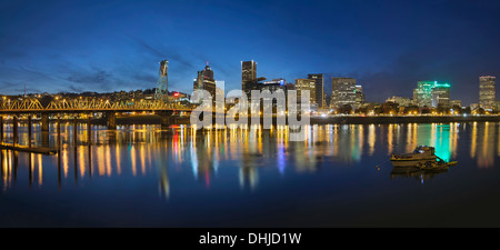 Portland Oregon Skyline der Innenstadt mit Hawthorne Bridge entlang den Ufern des Willamette River bei der abendlichen blauen Stunde Panorama Stockfoto