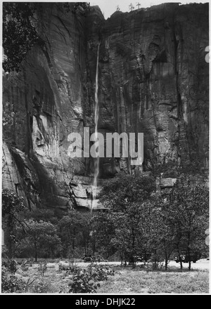 Ein Wasserfall, der aus einem hängenden Tal am Tempel der Sinawava im Zion-Nationalpark fällt. Der Wasserfall wird während eines Regensturms beobachtet, was den dynamischen Fluss des Wassers aus dem Tal hervorhebt. Stockfoto