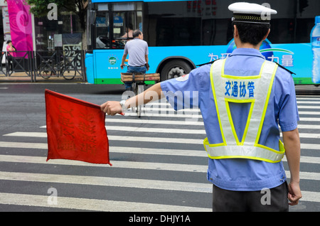 Verkehrssicherheit in China: Polizist Regie Verkehr und Fußgänger an einer großen Kreuzung. Stockfoto