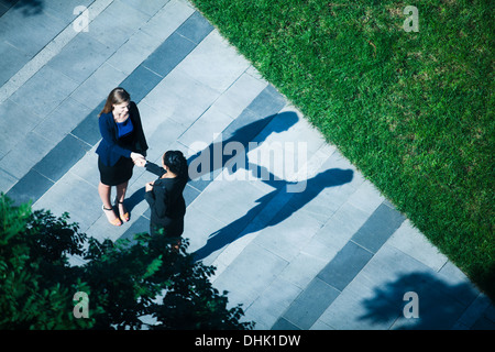 Luftaufnahme von zwei Geschäftsfrauen Händeschütteln auf dem Bürgersteig Stockfoto