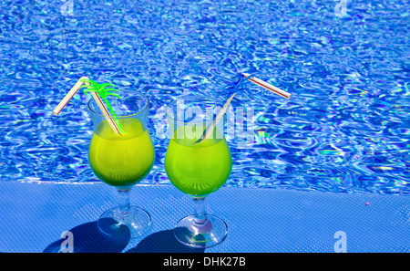 Gläser mit Cocktail am Rand des Pools Stockfoto