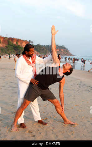 Indische Yoga-Lehrer und Schüler am Strand in Varkala, Indien. Stockfoto