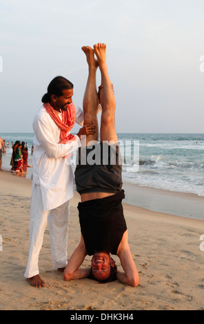 Indische Yoga-Lehrer und Schüler am Strand in Varkala, Indien. Stockfoto