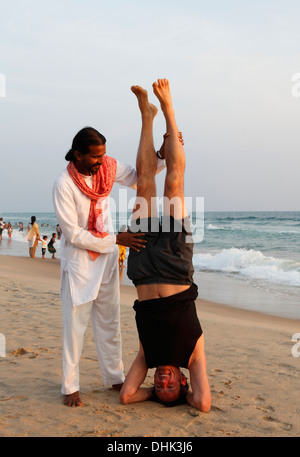 Indische Yoga-Lehrer und Schüler am Strand in Varkala, Indien. Stockfoto