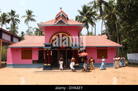 Eine Gruppe von Frauen mit angeboten und ein Priester Kreisen einen Hindu-Tempel in Varkala, Indien Stockfoto