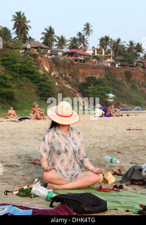 Junge Frau in einer Meditation Position am Strand in Varkala, Kerala, Indien Stockfoto