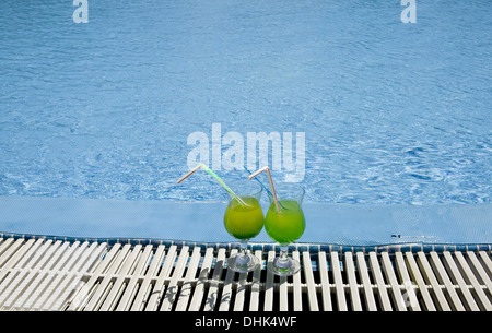 Gläser mit Cocktail am Rand des Pools stehen Stockfoto