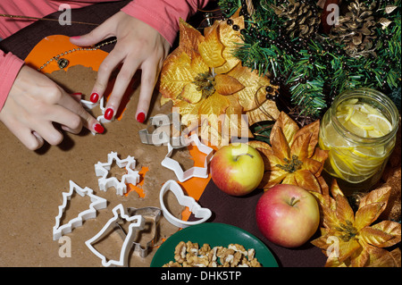 Weibes Hände schneiden Lebkuchen. Weihnachtstisch. Stockfoto