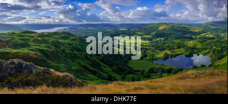 Ein Blick vom Loughrigg in Richtung Windermere in der Ferne, am Morgen mit Schatten auf die Landschaft. Stockfoto