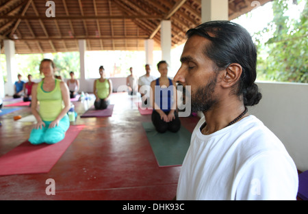 Yogalehrer mit seinen Schülern in Varkala, Indien zu meditieren. Stockfoto