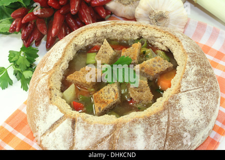 ein Bauernbrot gefüllt mit einer bunten Brotsuppe Stockfoto