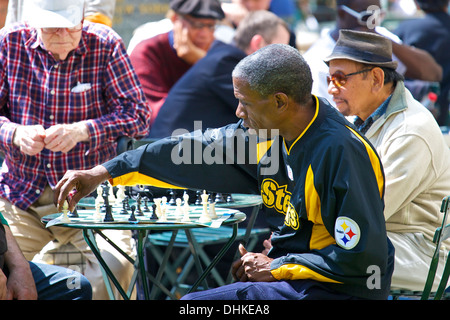 Gruppen von Männern beim Schachspiel im Bryant Park in New York City. Stockfoto