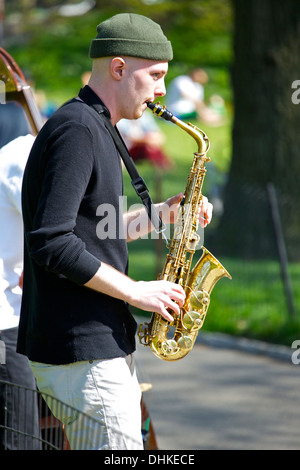 Messing im Park, ein junger Musiker spielt das Saxophon im Central Park in New York City. Stockfoto