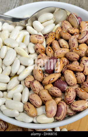 getrocknete weiße und rote Bohnen auf Schneidebrett Stockfoto